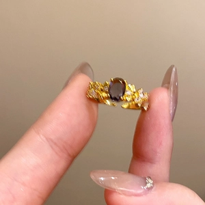 Macro detail of vintage gold floral ring with oval purple gemstone and accent diamonds