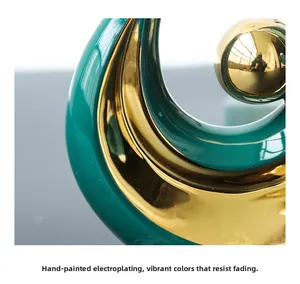 Close-up of dark green ceramic phoenix statue with electroplated gold sphere finish