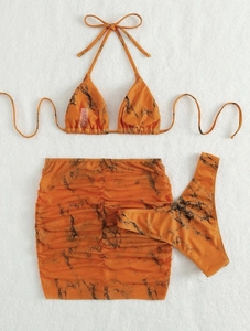 Detailed macro view of orange marble print three-piece bikini set with mesh skirt