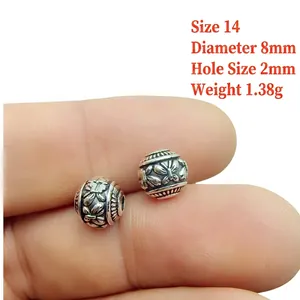 Detail of silver alloy beads with floral engraving, 8mm diameter and 2mm hole size