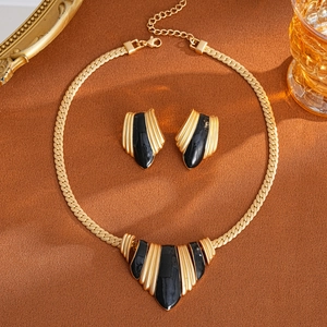 Detail of vintage gold flower jewelry set with black enamel and diamond accents