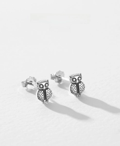 Macro view of S925 silver owl earrings with vintage finish and feather textures