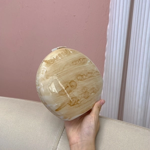 Detail of round marble texture hard shell clutch bag with smooth amber acrylic finish