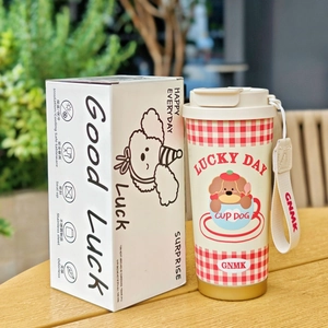 Detailed view of cream stainless steel coffee cup and gift box on wooden table