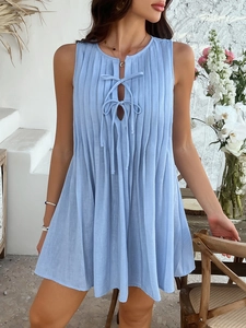 Detail of blue pleated sleeveless mini dress featuring lace-up neckline for summer vacation