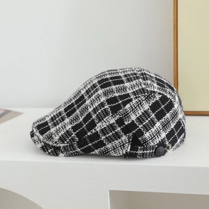 Detail of British style houndstooth wool beret with side decorative buckle