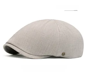 Détail de la casquette plate gris clair avec logo métallique doré et gravure lettre W