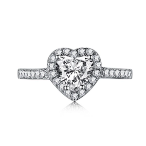 Macro shot of silver heart-shaped diamond ring with halo pavé setting and mirror reflection