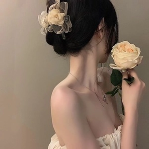 Elegant beige flower hair clip worn by model for a sophisticated and feminine look