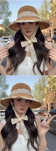 Detail of hand-woven straw hat featuring intricate lace ribbons and openwork wave texture