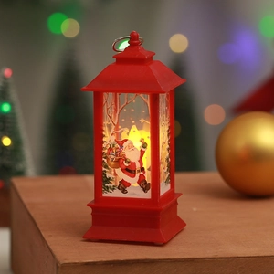 Detail of red Christmas lantern with Santa Claus illustration and warm LED candle light glow