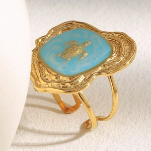 Detailed close-up of 18K gold plated turtle ring with blue enamel and hammered texture