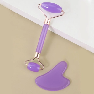 Detailed view of purple resin face roller set with rose gold metal and heart gua sha tool