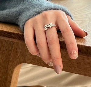 Close-up of a minimalist 925 sterling silver knotted ring worn on the index finger