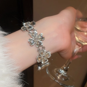 Close-up of sparkling silver heart crystal bracelet on wrist for an elegant dinner party