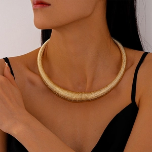Detail of chunky gold choker featuring a dense threaded metal texture on neck