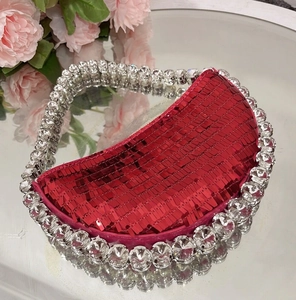 Macro detail of red sequin evening bag with sparkling rhinestone beaded handle