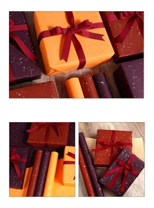 Detail showing premium orange and burgundy gift wrapping paper with gold foil texture