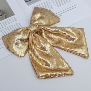 Detail shot of a double-layered Christmas bow featuring shimmering gold sequins on fabric