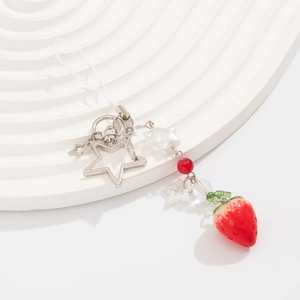 Dettaglio del ciondolo a fragola con stelle metalliche argentate e perle su base bianca