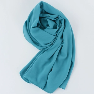 Elegant lake blue chiffon hijab scarf folded in a spiral design on white background
