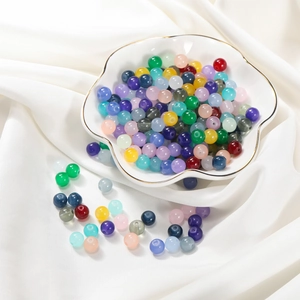 Macro view of 8mm colorful imitation jade glass beads for DIY jewelry making in a white bowl