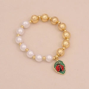 Detail of beaded bracelet with white pearls and ladybug charm on golden accents