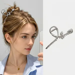 Dettaglio della molletta per capelli a rosa in metallo argento con design traforato