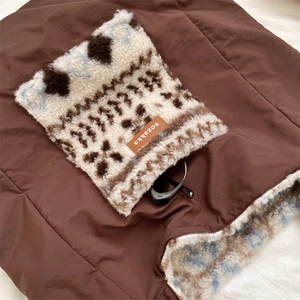 Detailed close-up of brown quilted canvas and plush ethnic pattern on commute bag