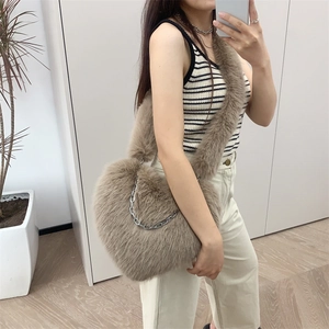 Detail view of heart-shaped plush crossbody bag in khaki featuring a silver metal chain