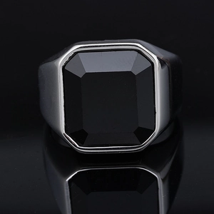 Macro shot of men's silver ring featuring a polished black rectangular gemstone