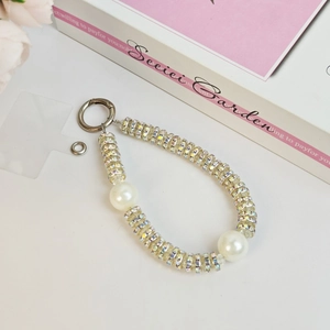 Detail of luxury beaded phone strap with transparent acrylic beads and large pearls