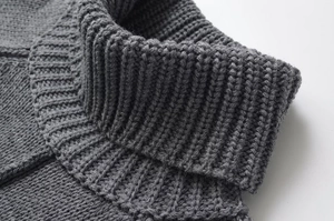 Detailed close-up showing the dark grey ribbed knit texture and stand-up collar of the sweater