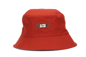Detail of red bucket hat showing durable canvas fabric texture and 1403 letter patch