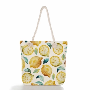 Detail of lemon print canvas tote bag with rustic nautical rope handles and summer fruits