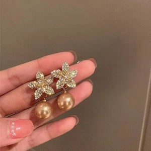 Elegant gold flower earrings with sparkling rhinestones and a hanging gold pearl drop