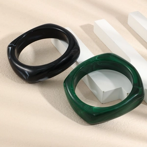 Detail view of luxurious square resin bangles with black and dark green marble textures