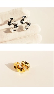 Detailed macro view showing the high-polished silver curved earring and gold textured ring