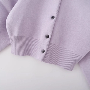 Lavender round neck knit cardigan with rib-knit hem and dark buttons on grey background