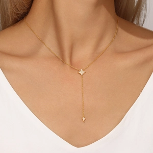 Detail of s925 silver star necklace with zircon fringe on golden metal chain