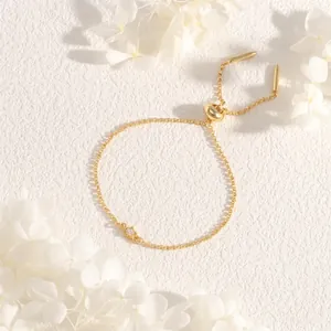 Detail view of gold star charm bracelet with micro-inlaid zircon and adjustable slider clasp