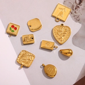 Detailed close-up of 18K gold plated stainless steel heart and cherry charms for DIY jewelry