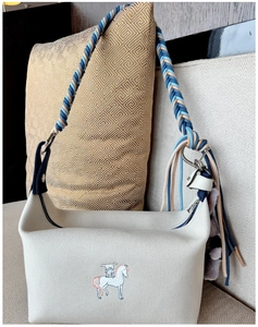 Detail of hand-woven blue and beige strap with fringe tassels on canvas handbag