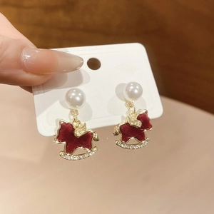 Close-up of red flocked rocking horse earrings with pearls and crystals detail