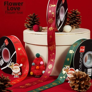 Detail of satin Christmas ribbons with gold foil snowflakes and Merry Christmas prints
