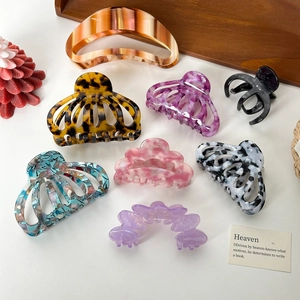 Assorted colorful acetate hair claws in various marble and floral patterns for styling
