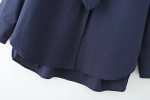 Detail of navy blue cotton shirt showing hemline, buttons, and high-quality poplin texture