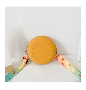 Detail of round ginger yellow silicone crossbody bag with colorful cartoon food strap