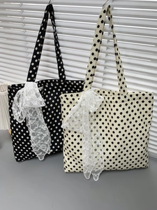 Close-up of polka dot canvas tote bags in black and cream with lace bow details
