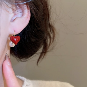 Primo piano di orecchini a cuore di fragola e perla su modella con stile rétro elegante
